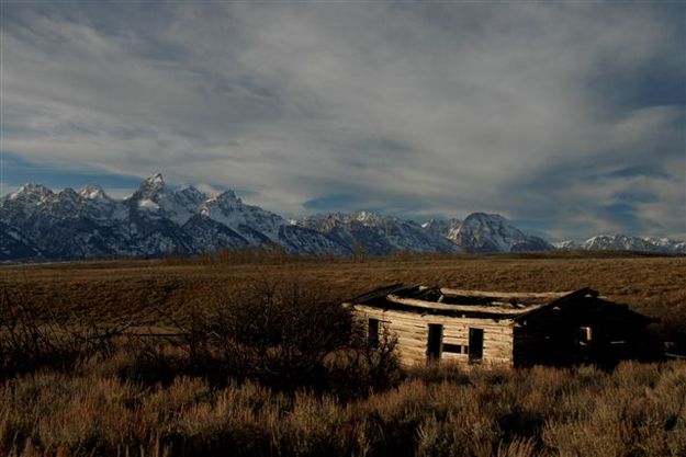 Tetons and cabin. Photo by Arnold Brokling.