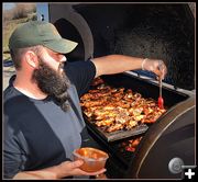 Stoney Bastes his Smoked Chicken Wings. Photo by Terry Allen.